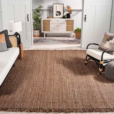 a living room with white furniture and brown rugs on the floor in front of it