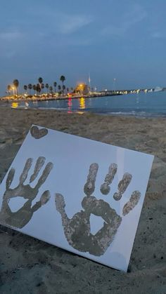 a hand and foot prints are placed on the beach