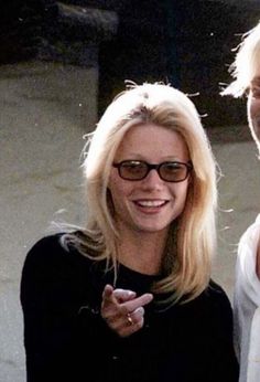 two women standing next to each other with one pointing at the camera and smiling for the camera