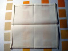 an empty piece of white paper on top of orange and yellow striped tablecloths