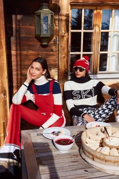 two women sitting at a table with food in front of them