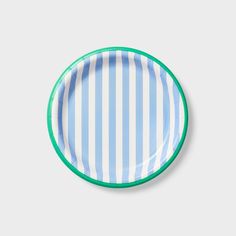 a blue and white striped plate with green rims on a grey background, top view