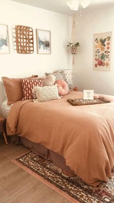 a bed sitting on top of a wooden floor next to a wall with pictures above it