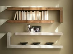 three bowls are sitting on the shelf in front of some books