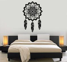 a bedroom with a bed, nightstands and wall decal in the shape of a dream catcher