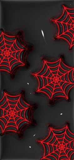 some red and black spider webs are in the water on a dark background,