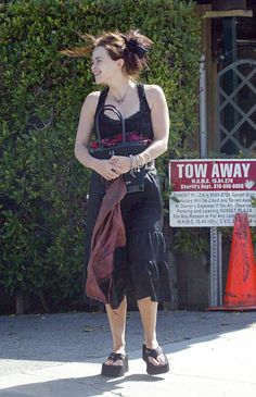 a woman in black dress walking down the street