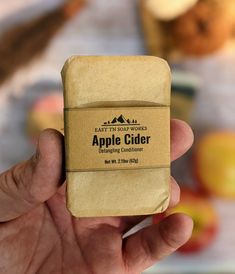 a hand holding an apple cider soap bar