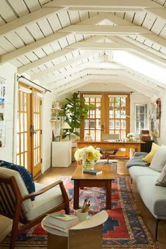 a living room filled with lots of furniture and decor on top of a wooden floor