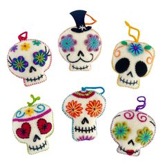 four sugar skull ornaments in different colors