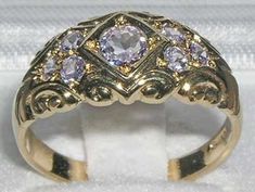 *This ring is made from 375 9K Yellow Gold with Natural TanzanitesA beautiful Victorian Style Tanzanite Ring set with a centre 4.5mm (0.18" inches) and six 2.25mm (0.09" inches)  Tanzanites set in a gorgeous 9ct Gold setting. PLEASE MAKE SURE YOU STATE THE FINGER SIZE YOU REQUIRE WITH YOUR PAYMENT.Completely made from Solid English 9K Gold Hallmarked by the London Assay Office which confirms the rings authenticity. The Hallmark includes the 375 marking for 9K Gold. This is a delightful piece to Pink And Gold Rings, Heirloom Amethyst Ring With Diamond In Gold, Heirloom Gold Amethyst Ring With Diamond, Gold Amethyst Ring With Brilliant Cut For Wedding, Gold Brilliant Cut Amethyst Ring For Wedding, Brilliant Cut Gold Amethyst Ring For Wedding, Heirloom Gold Amethyst Ring With Rose Cut Diamonds, Gold Amethyst Ring With Rose Cut Diamonds For Anniversary, Heirloom Gold Amethyst Ring For Weddings