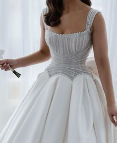 a woman in a white dress holding a flower