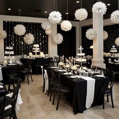 a room filled with tables covered in black and white decorations