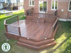 a wooden deck in front of a brick house