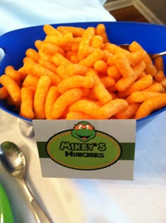 a blue bowl filled with cheetos sitting on top of a white table cloth