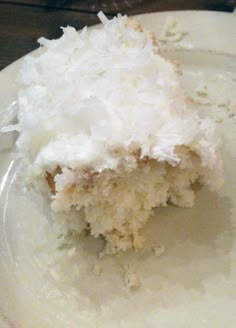 a piece of coconut cake sitting on top of a white plate