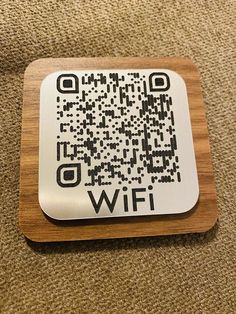 a wooden coaster with a qr code on it sitting on a carpeted floor