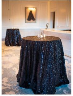 the table is covered with black sequins and has two candles on each side