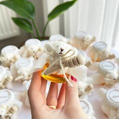 a hand holding a small bottle with honey in it