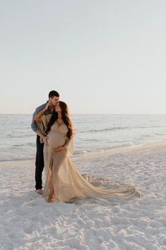 a man and woman kissing on the beach