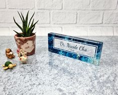 a small potted plant next to a sign on a table