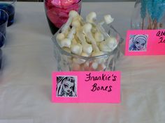 there is a table that has pink and white candies in a bowl on it