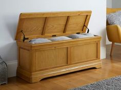 a large wooden chest sitting on top of a hard wood floor next to a yellow chair