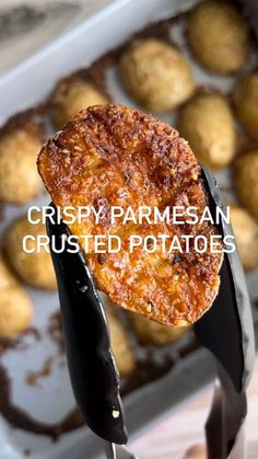 a close up of a fork with some food on it and the words crispy parmesan crusted potatoes