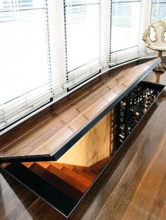 a long wooden table in the middle of a room with windows and blinds on both sides