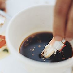 a person is dipping some food into a cup