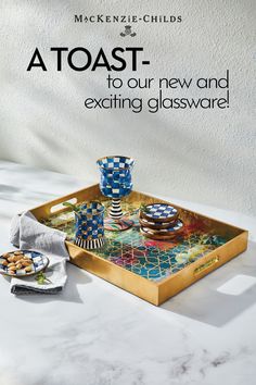 a table with plates and cups on it that says toast to our new and exciting glassware