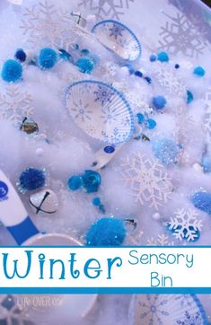 snowflakes, scissors and other items in a bowl with the words winter sensory bin