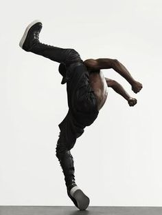 a man doing a handstand in front of a stack of books with his feet on the floor