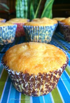 several muffins sitting on top of a blue and green table cloth