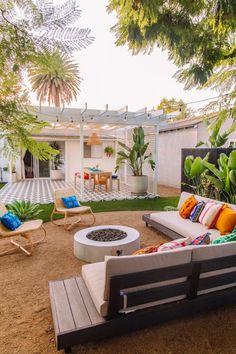 an outdoor living area with couches, chairs and fire pit in the back yard