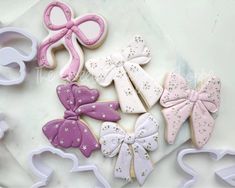 decorated cookies and cookie cutters sitting on top of a white countertop next to each other