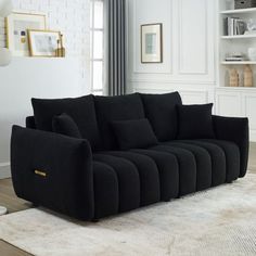 a black couch sitting on top of a white rug