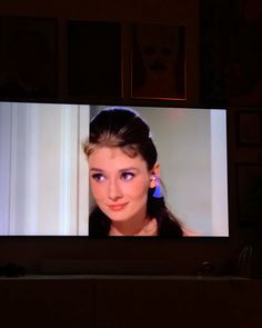 a television screen with a woman's face on it and an earring in front of her