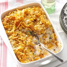 a casserole dish with chicken and rice in it on a table next to a bottle of water