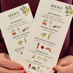 two people holding up menus with different food items on them, and one person wearing red nail polish