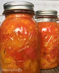 two mason jars filled with pickles and tomatoes