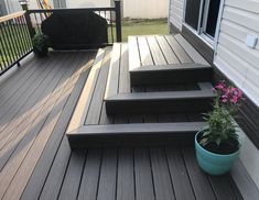 a potted plant sitting on top of a wooden deck next to steps and railing