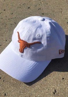 This Texas Longhorns White Adjustable Hat features a front embroidered team logo on a lightly structured crown with pre-curved visor and adjustable strapback. New Era 9TWENTY, Front embroidered team logo, 6-panel crown design with eyelets, Fabric self strap, Adjustable Closure, Cotton material, Cotton, Washable, 4 Curved Bill Hat With Team Logo For Sports Event, Collegiate Snapback Hat With Curved Bill, Team-colored Curved Brim Hat For Fans, White Baseball Cap With Curved Visor For Fans, Team-colored Hat With Curved Brim For Fans, White Snapback Hat For Game Day, Fan Gear Visor Hat, One Size Fits Most, Collegiate Adjustable Trucker Hat With Curved Brim, Collegiate Fitted Hat With Curved Visor For Game Day