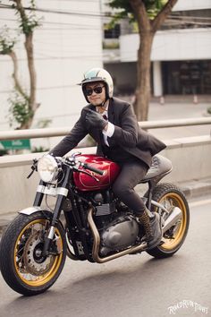 a man riding on the back of a red motorcycle