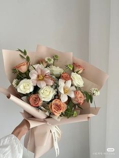 a woman holding a bouquet of flowers in her hand