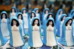 some little figurines are lined up on a table with blue cloth around them