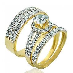 two gold wedding rings with diamonds on each band and an oval cut diamond in the center