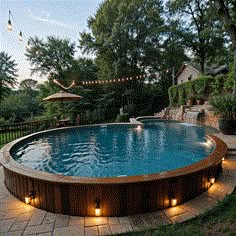 a backyard pool with lights around it