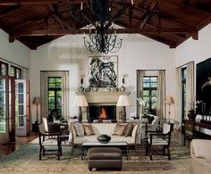 a living room with couches, chairs and a chandelier in it's center