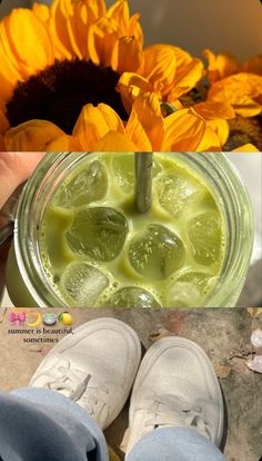 a person holding a mason jar filled with lemon slices and limeade in front of sunflowers